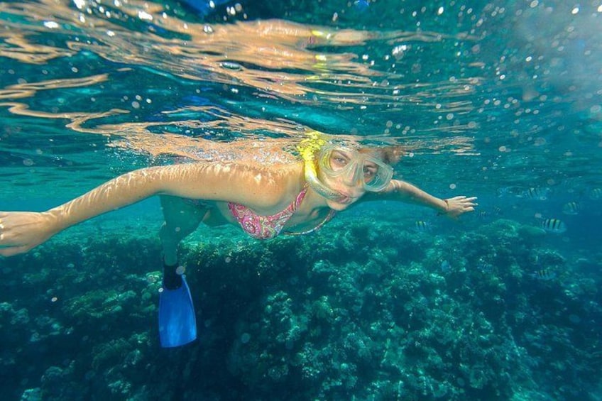 Una persona practica snorkel bajo el agua con aletas y un tubo de respiración. 3