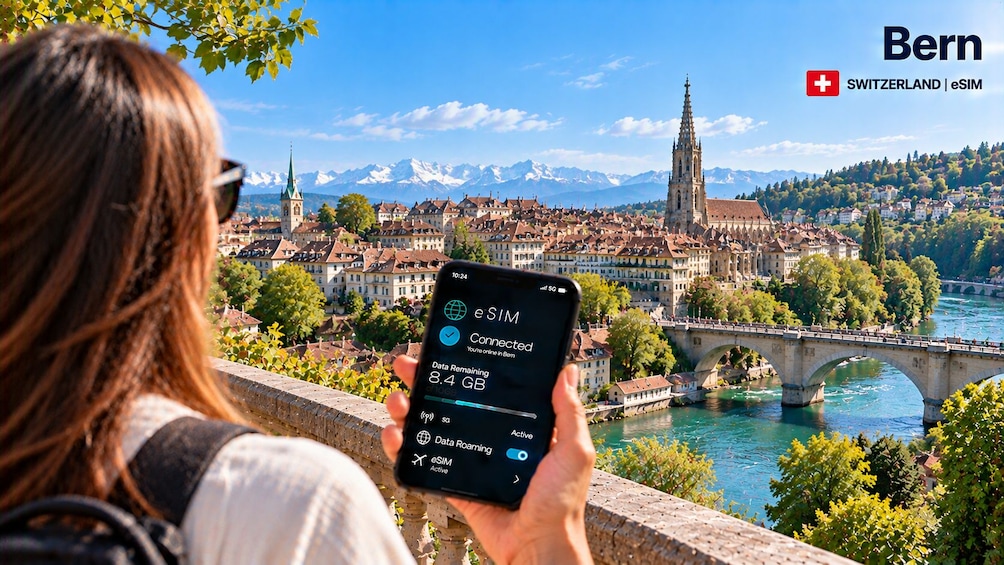 Una persona sosteniendo un teléfono inteligente con un paisaje urbano al fondo. 1