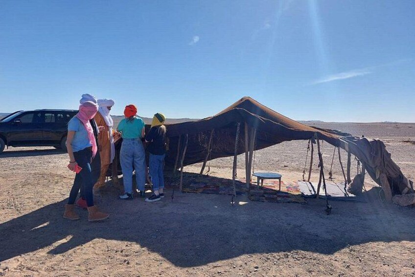 Un grupo de personas junto a una estructura grande y derrumbada en un paisaje desértico. 2