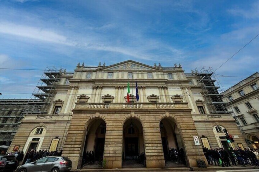 A historic building with a central entrance, columns, and a flagpole. 5