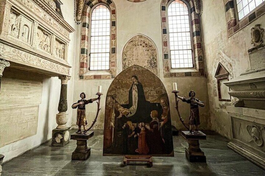 An ornate church interior with a central religious painting, arched windows, and classical architectural details. 2