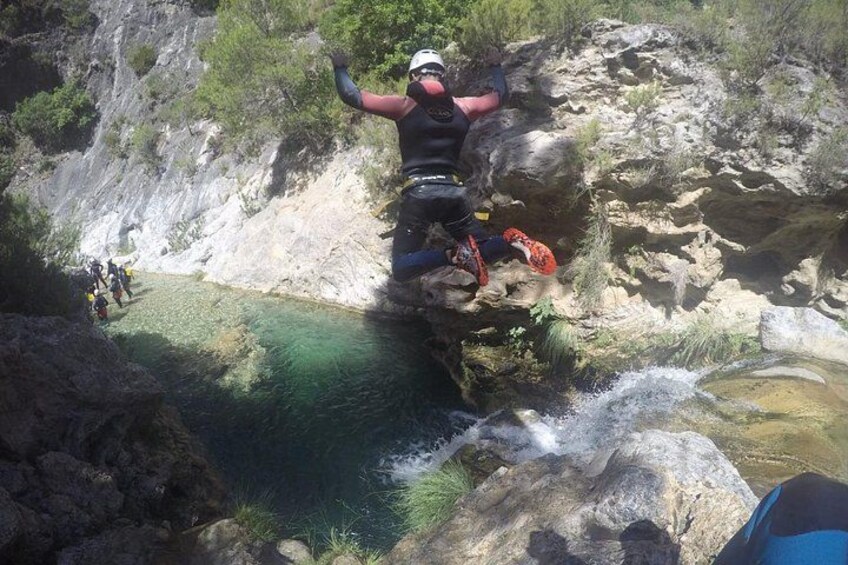 Una persona haciendo bungee jumping desde un acantilado rocoso hacia una masa de agua. 5