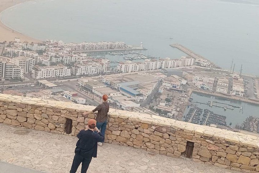 Eine Küstenstadt mit Gebäuden, einem Strand und einem Hafen. 3