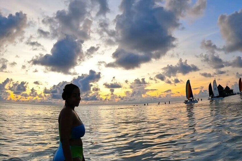 Un atardecer sobre un cuerpo de agua con veleros. 1