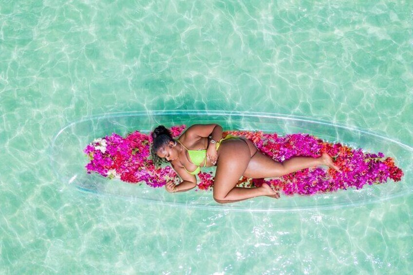 Une personne allongée sur un flotteur dans une piscine, entourée de fleurs aux couleurs vives. 4