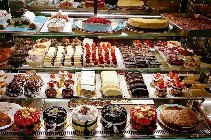 A variety of desserts displayed in a glass case. 3