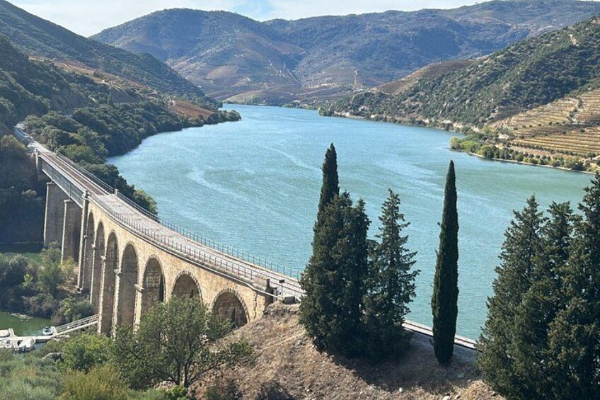 A bridge over a river, surrounded by hills and trees. 1