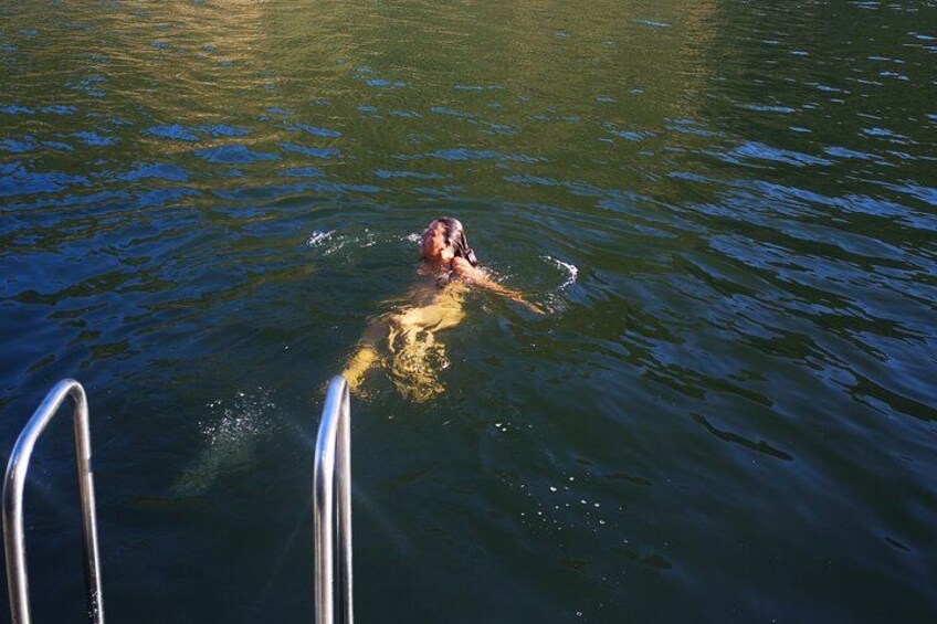 A person swimming in a body of water with metal ladder structures visible in the foreground. 2