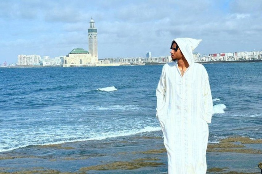 A person standing by the sea with a cityscape in the background. 1