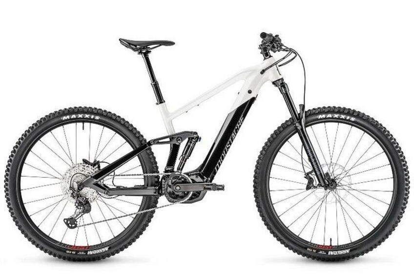 Un vélo de montagne blanc avec un cadre noir, un dérailleur arrière et des pneus à crampons. 3