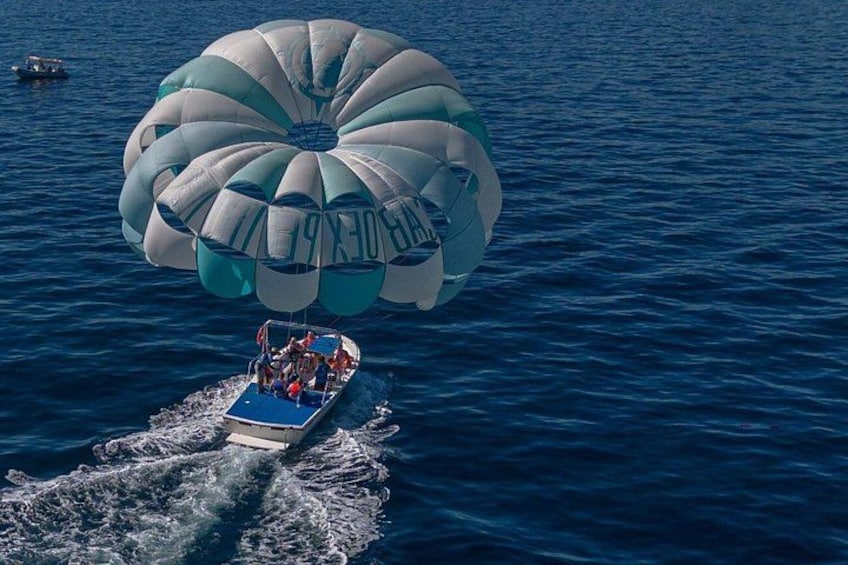 Actividad de parasailing con un barco y un paracaídas grande sobre el agua. 4