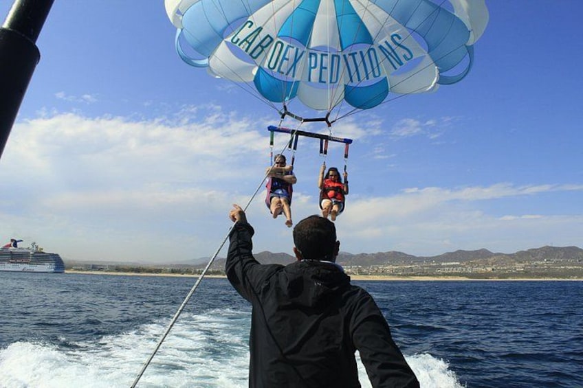 Una persona parapente sobre el agua, con un paracaídas que dice 'CABO DE PEDRONIS'. 5