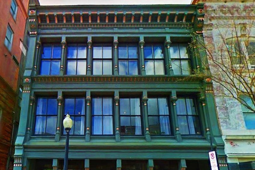 Un edificio verde con varias ventanas y una farola. 2