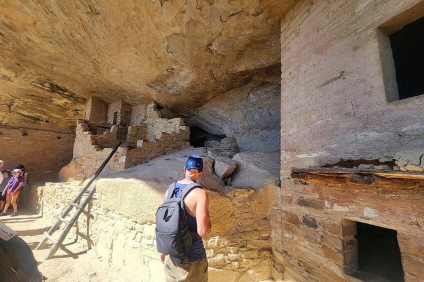 A person climbing a stone staircase in an ancient ruin. 4