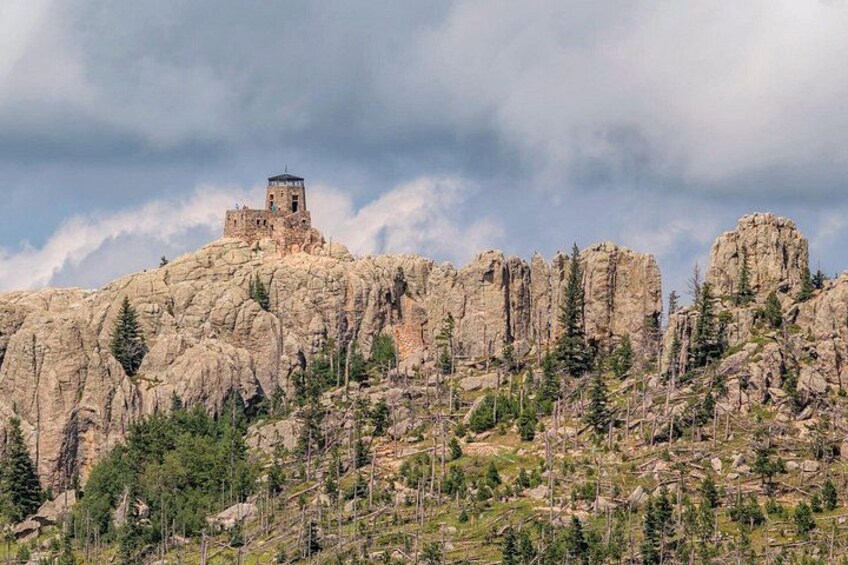 A rocky mountain with a small tower-like structure on top. 3