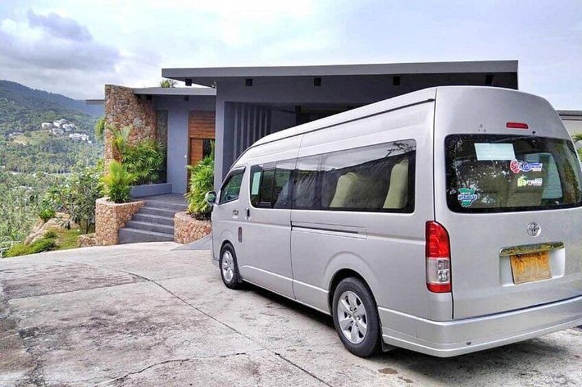 Una camioneta plateada estacionada frente a una casa moderna con fachada de piedra y vistas a un paisaje montañoso. 5