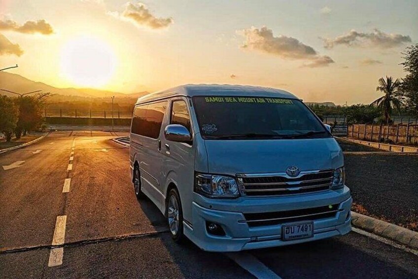 Una camioneta blanca estacionada en una carretera, con un atardecer de fondo. 3