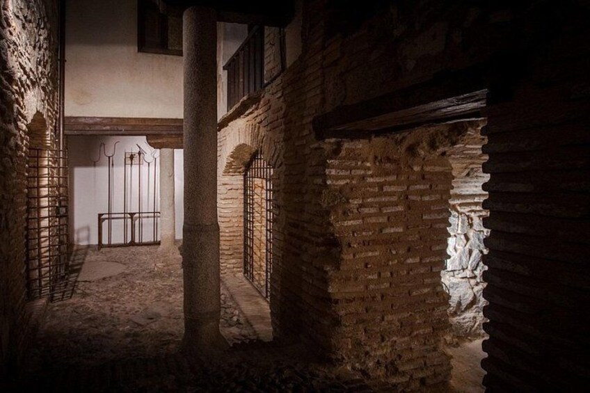 Un antico edificio in pietra con portali ad arco e una colonna centrale. 3