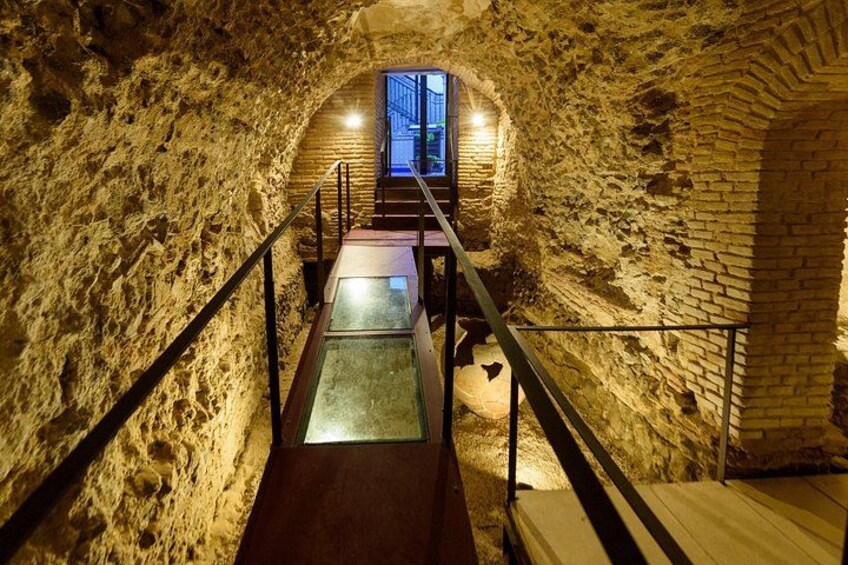 Una scala in pietra conduce a un livello superiore, con ringhiera in legno e balaustre in metallo. 5