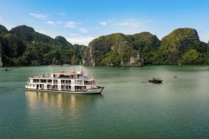 A large white boat on calm water with green hills in the background. 3