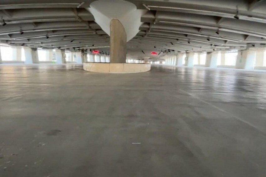 An empty parking garage with concrete floors and columns. 3