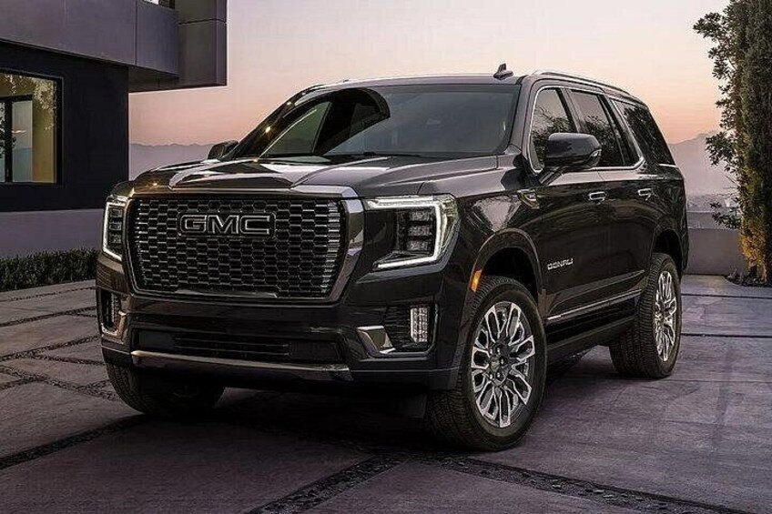 A black GMC SUV parked on a driveway. 2