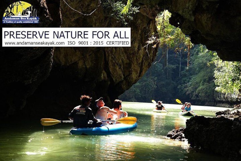 People kayaking on a river with a cave in the background. 5