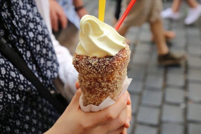 A person holding a dessert with a yellow and red striped straw. 4