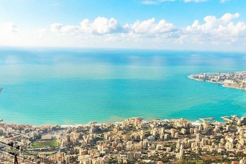A coastal cityscape with a clear view of the sea and a distant island. 3