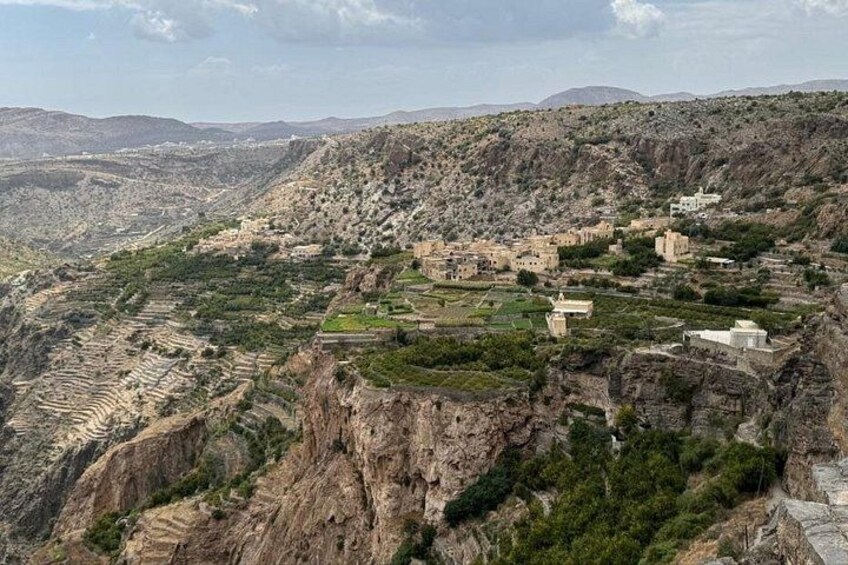 A rugged mountainous landscape with terraced fields and scattered buildings. 2