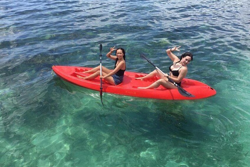 Two people kayaking on a red kayak in clear blue water. 5