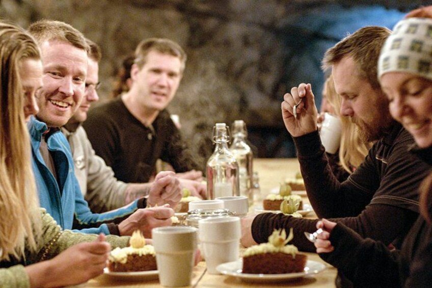 A group of people sitting around a table with food and drinks. 4