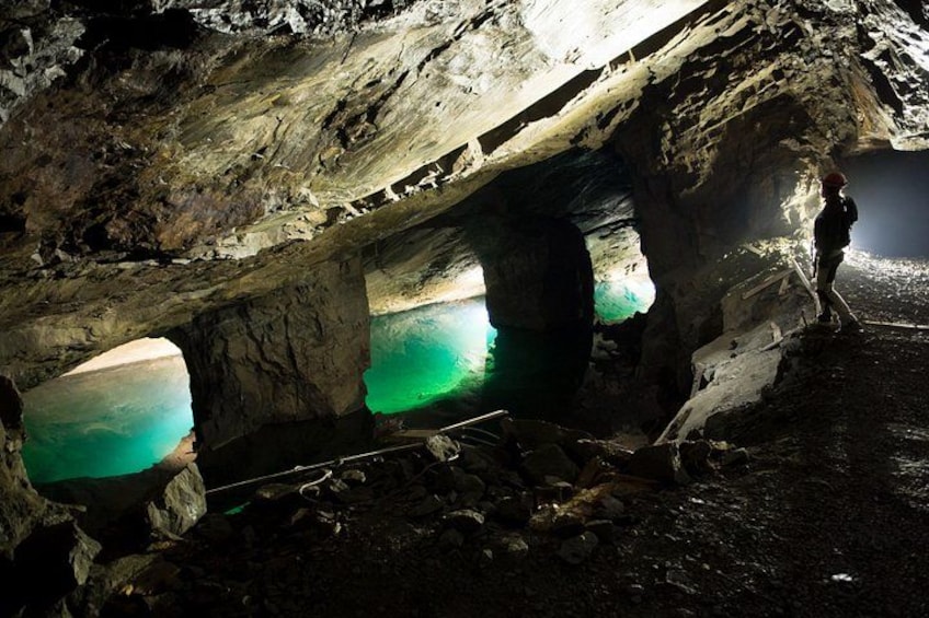 A cave with natural rock formations and a water pool. 2