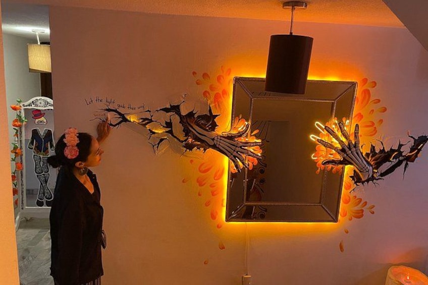 Een persoon die een wandkunstinstallatie bedient met een geometrisch frame en verlichte elementen. 4