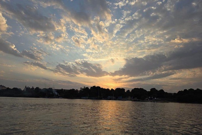 Un atardecer sobre un cuerpo de agua con nubes reflejándose en la superficie. 3
