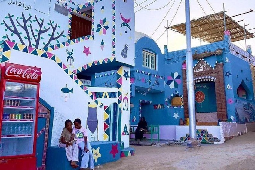 Un edificio colorido con diseños geométricos y un refrigerador Coca-Cola. 5