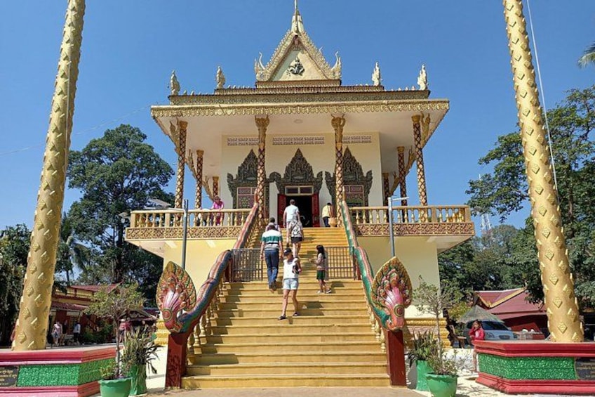 A temple with a golden roof, stairs, and two large golden trees. 1
