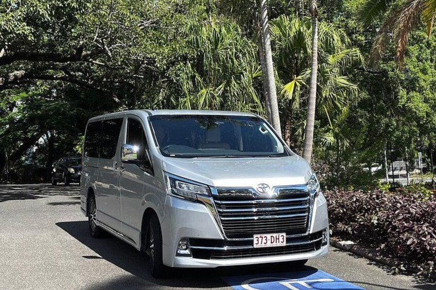 Una minivan plateada estacionada en una calle con un letrero azul de estacionamiento para discapacitados. 4