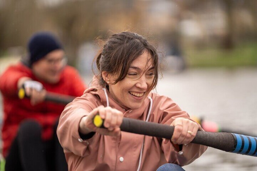 Two people rowing a boat on a calm body of water. 3