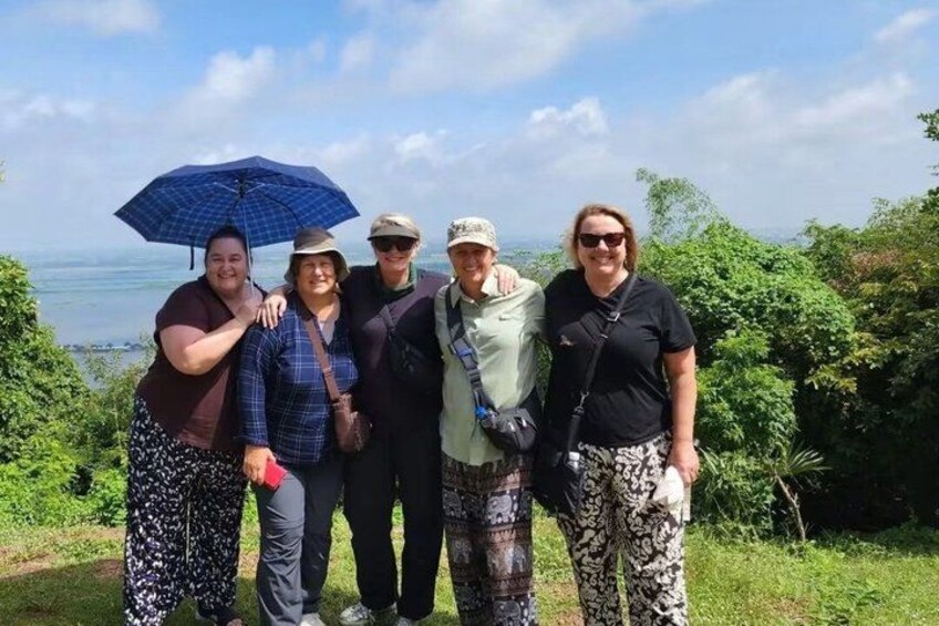 Un groupe de personnes se tient sur une colline herbeuse, d’où l’on a une vue sur l’océan. 5