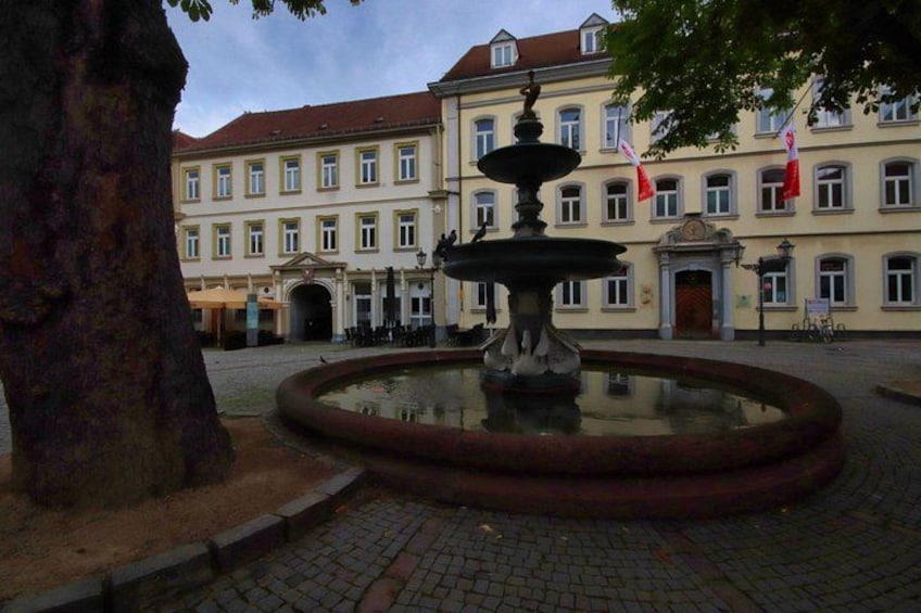 A fountain in a courtyard with a building in the background. 4