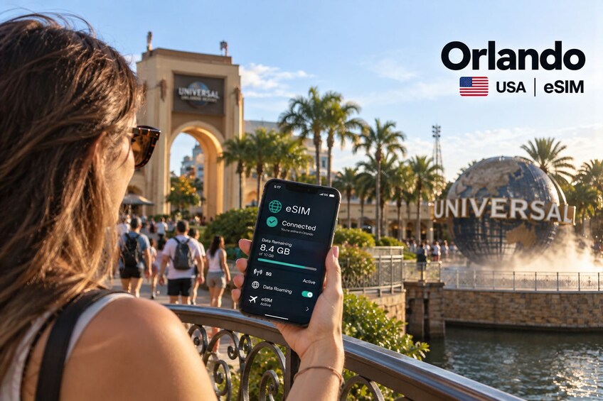 A person holding a smartphone displaying eSIM data usage, with Universal Orlando in the background. 1