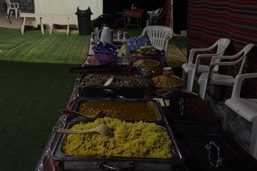 Una mesa de buffet con diversos platos, incluyendo arroz amarillo y otros alimentos. 3