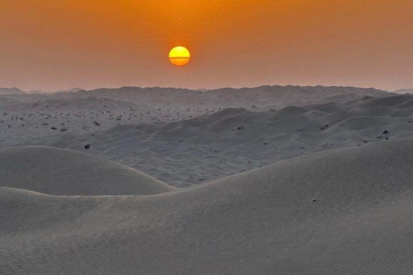 Paisaje desértico con dunas de arena y un sol poniente. 5