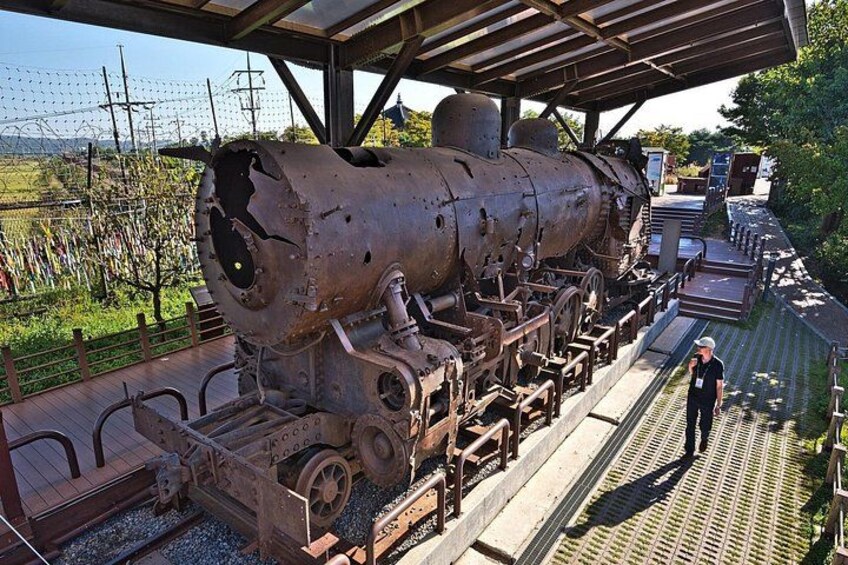 Eine große, verrostete Lokomotive, ausgestellt an einem Bahnhof. 2