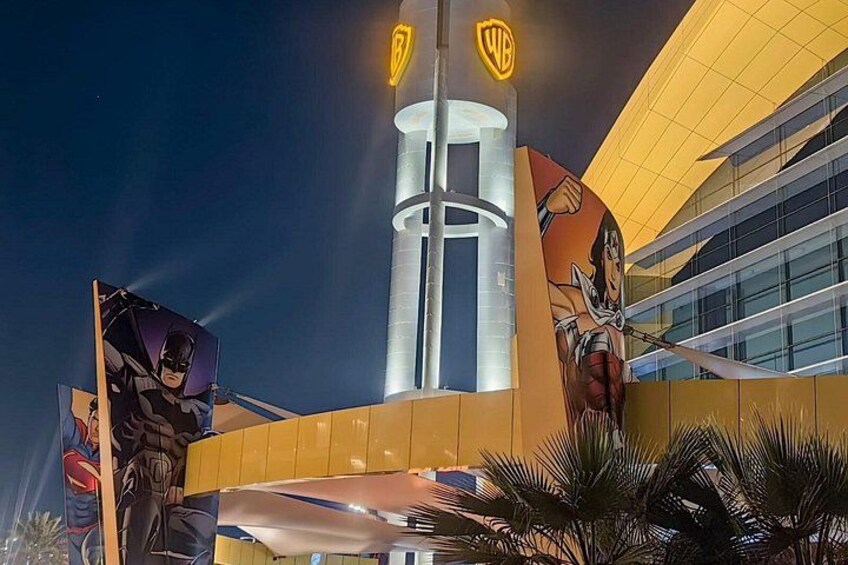 A building with a Warner Bros. sign, a large Batman statue, and a large Wonder Woman statue. 3