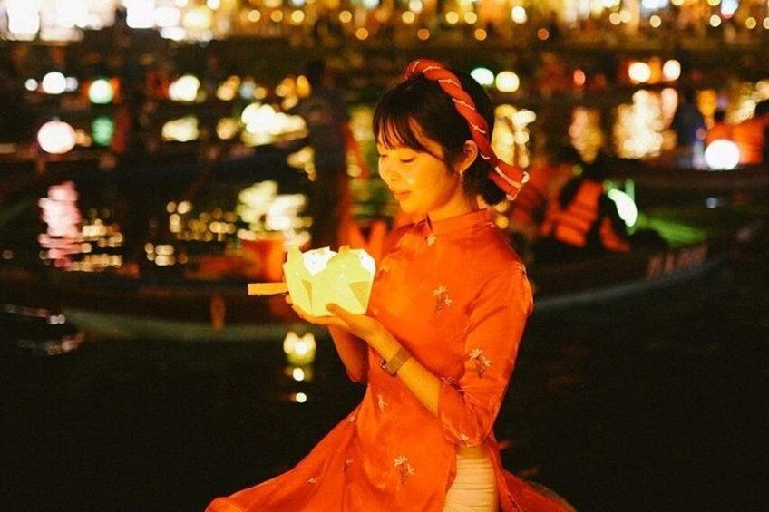 A person in a red dress holding a lantern at night. 4