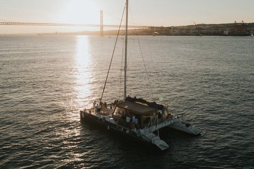 A sailboat on calm water with a bridge in the background. 3