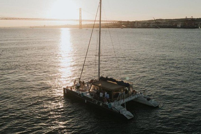 A sailboat on calm water with a bridge in the background. 2