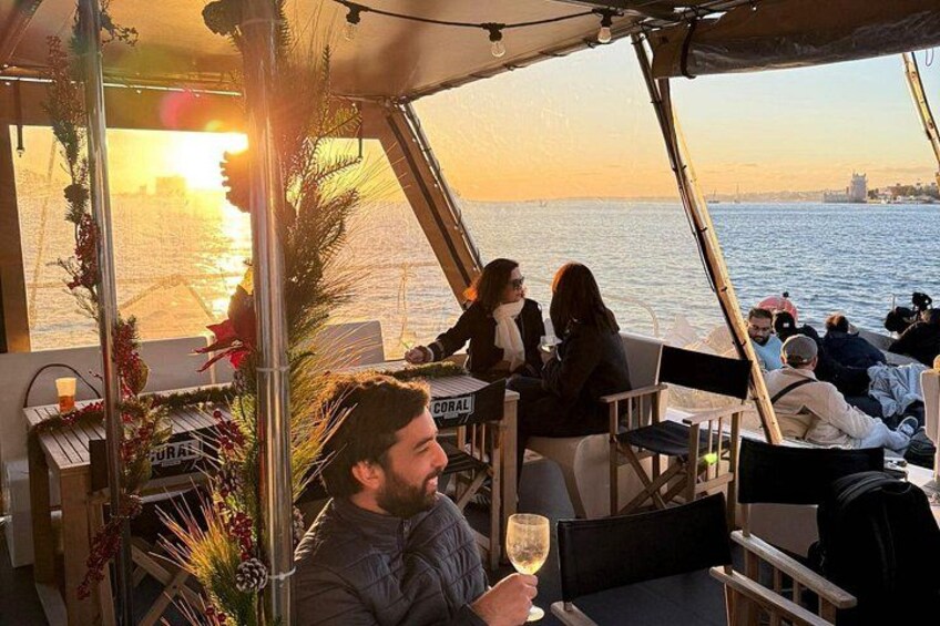 A boat with people enjoying drinks and the sunset in the background. 4